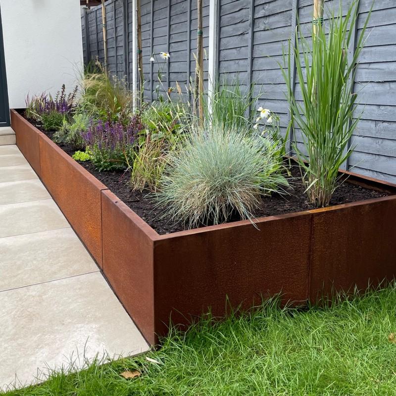 Tiered corten steel retaining wall system on a steep suburban block.