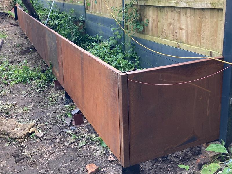Clean architectural lines of metal retaining walls in a minimalist landscape.