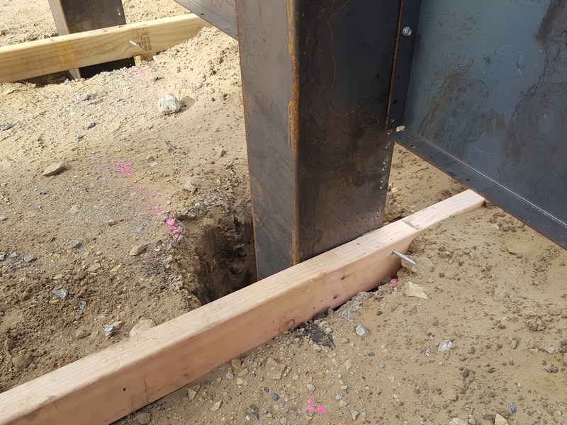 corten steel support post braced while concrete sets